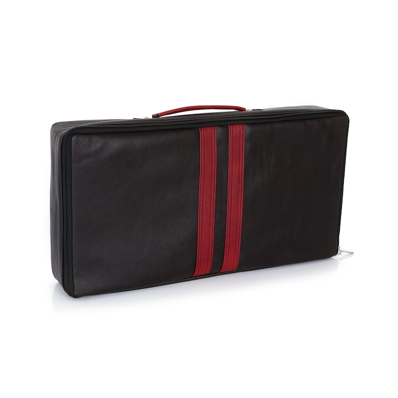 Peut inclure: Valise de voyage noire avec une bande rouge au centre. La valise a une fermeture &eacute;clair et une poign&eacute;e.