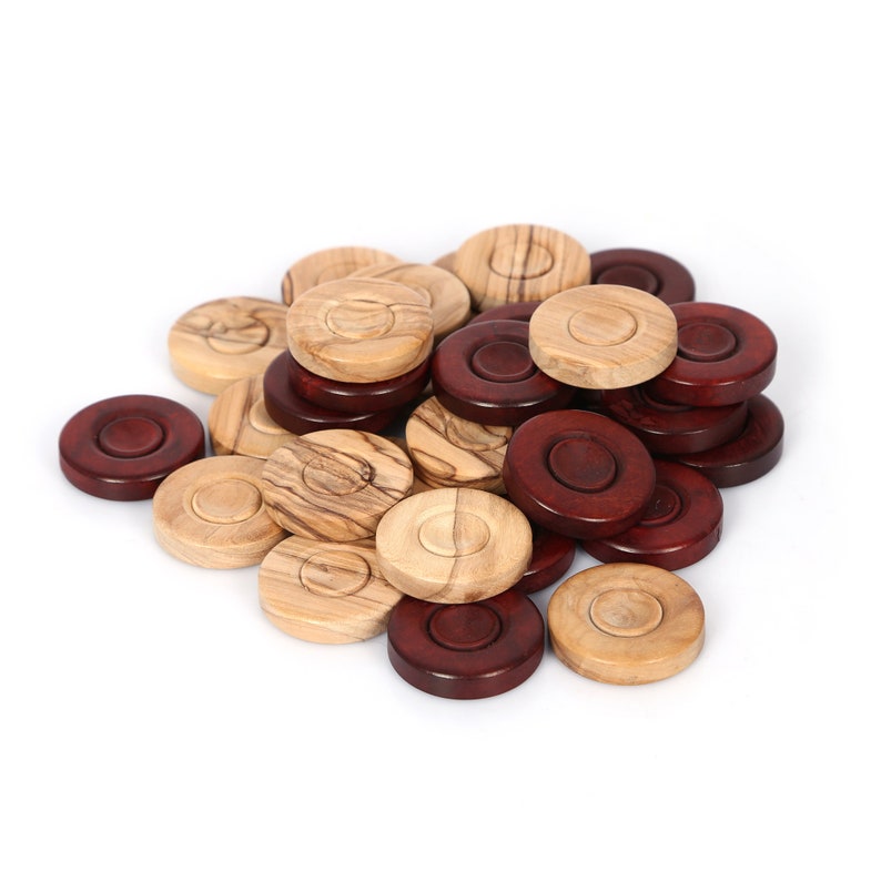 Peut inclure: Un tas de pions de jeu en bois dans des tons bois&eacute;s naturels et bruns. Les pions sont ronds et ont une l&eacute;g&egrave;re indentation au centre.