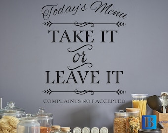 May include: A kitchen wall decal with the text "Today's Menu Take It or Leave It Complaints Not Accepted". The decal is in black lettering with decorative arrows and swirls. The decal is on a gray wall with various glass jars and kitchen utensils in the foreground.