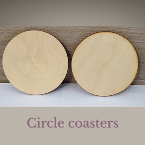 May include: Two unfinished, round wooden coasters. The coasters are made of light-colored wood and have a smooth surface.  Circle coasters.