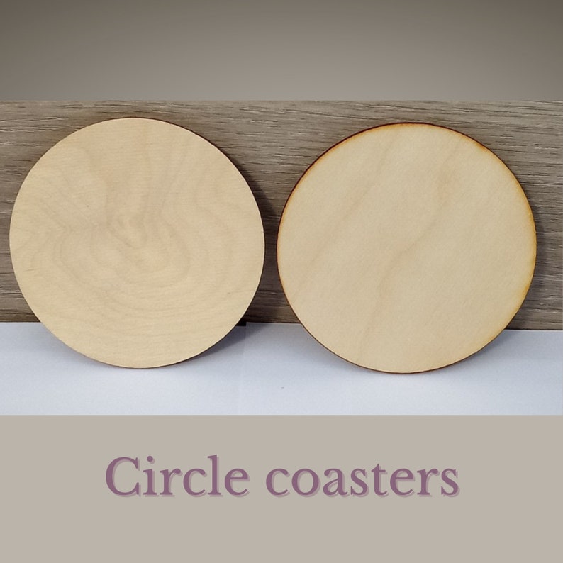 May include: Two unfinished, round wooden coasters. The coasters are made of light-colored wood and have a smooth surface.  Circle coasters.