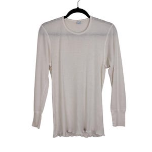 Könnte beinhalten: Cremefarbenes Langarm-Thermo-Shirt mit Rundhalsausschnitt und Rippstruktur. Das Shirt hängt an einem schwarzen Kleiderbügel vor weißem Hintergrund. Die Manschetten und der Saum haben einen fertigen Rand.