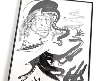 以下が含まれることがあります： 黒と白の額装されたアートワーク。イラストは、触手やその他のシュールな要素を持つ男性の顔を描いています。イラストは黒いフレームに収められています。