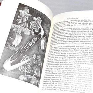 May include: An open book with a black and white illustration of a curved horn-like object with a detailed design, figures, and ships. The text on the page is in English.