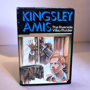 May include: A paperback book cover with a black background and a blue title "Kingsley Amis" and the subtitle "The Riverside Villas Murder". The cover features an illustration of a man looking out a window and a young boy looking up.