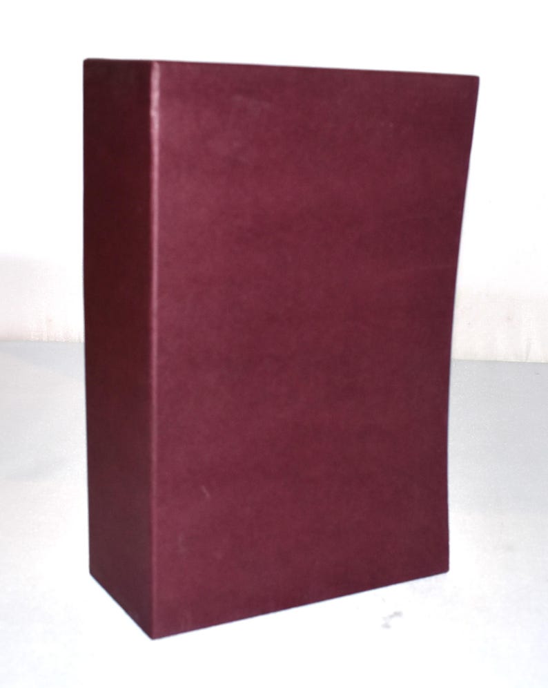 May include: A rectangular, burgundy-colored box with a slightly curved side. The box has a matte finish and is set against a white background. The box appears to be made of a sturdy material.