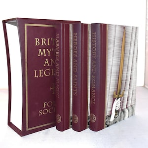 May include: A collection of hardcover books with burgundy covers and gold lettering. Titles include "British Myths and Legends," "Marvels and Magic," "Heroes and Saints," and "History and Romance." The spine of the last book features a gold sword illustration.