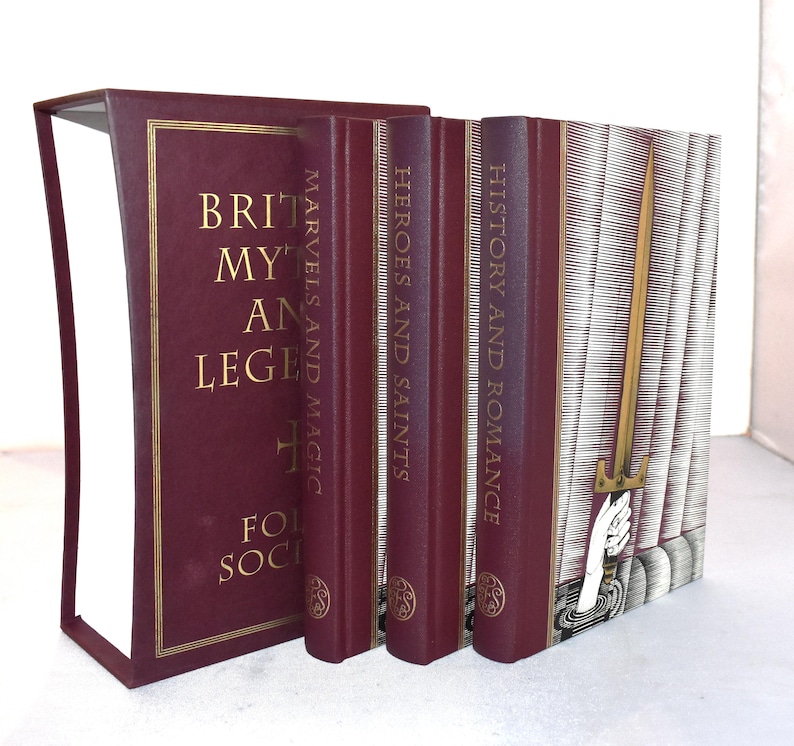 May include: A collection of hardcover books with burgundy covers and gold lettering. Titles include "British Myths and Legends," "Marvels and Magic," "Heroes and Saints," and "History and Romance." The spine of the last book features a gold sword illustration.