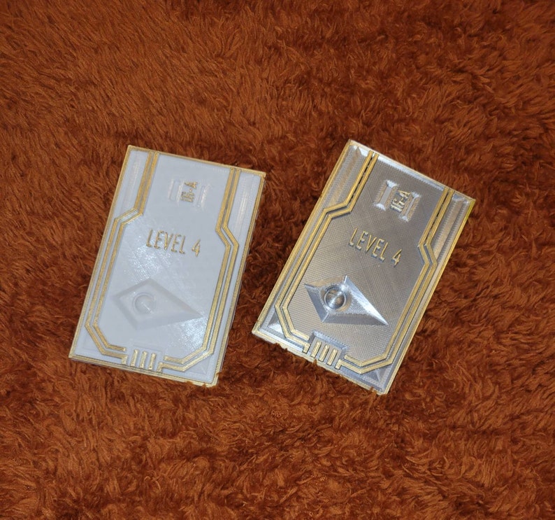 May include: Two white and silver plastic cards with gold trim. The cards have a raised design and the text "LEVEL 4" on them.