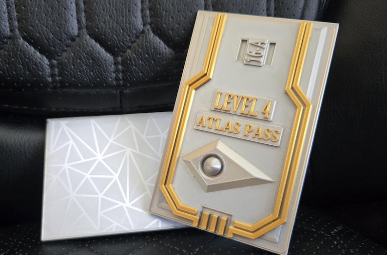 May include: A gold and silver key card with the text "Level 4 Atlas Pass".