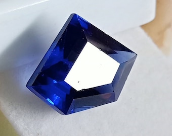 Può includere: Una pietra preziosa blu scuro con forma rettangolare sfaccettata.