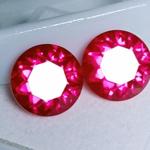 May include: Two bright pink ruby gemstones with a faceted octagonal shape and a clear center.