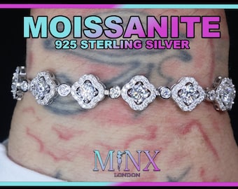 Op de afbeelding: Een zilveren armband met een rij van heldere, ronde stenen gezet in een klaverblad ontwerp. De armband is gemaakt van 925 sterling zilver en is gelabeld "Moissanite 925 Sterling Silver".