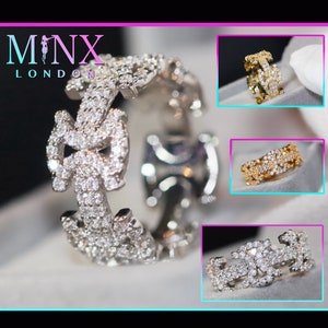 Op de afbeelding: Drie diamanten ringen in verschillende metaalafwerkingen: zilver, goud en roségoud. Elke ring heeft een uniek in elkaar grijpend ontwerp met pavé-gezet diamanten.