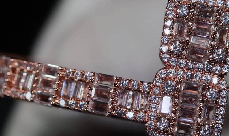 May include: A rose gold band ring with a row of baguette-cut diamonds set in a pave setting.