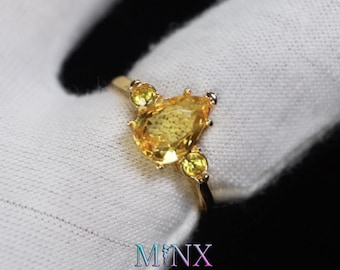 Anillo de compromiso de oro con diamantes amarillos talla pera para mujer.