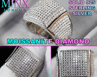 Puede incluir: Un anillo cuadrado de plata de ley 925 maciza incrustado con diamantes de moissanita. El anillo presenta un diseño de dos tonos con una base plateada y detalles dorados. El anillo es de la marca MINX LONDON.