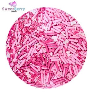 Puede incluir: Una disposición circular de chispas rosas, que incluye varillas, triángulos y formas de lazo. Las chispas varían en tonos de rosa, de claro a oscuro, creando una textura visualmente atractiva. El logotipo de SweetBerry Treats está en la esquina superior izquierda.