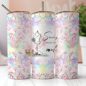 May include: Three stainless steel tumblers with a floral pattern and the text "Sewing Mends The Soul" with a sewing needle and button graphic.