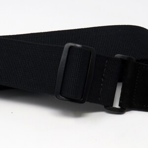 May include: Black guitar strap with a black leather end and a black metal buckle.