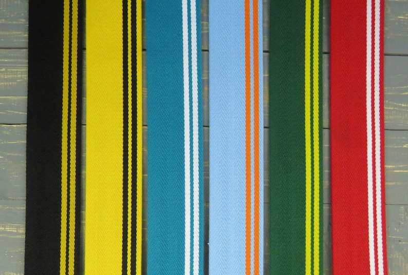May include: Six different striped fabric straps with various color combinations. The straps are black and yellow, yellow and black, teal and white, light blue and orange, dark green and yellow, and red and white.