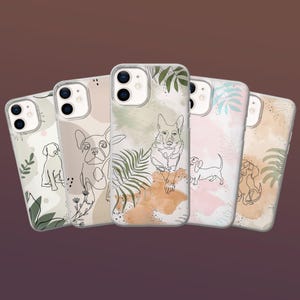 May include: A collection of five phone cases featuring line art dog illustrations. Each case has a different dog breed design, with a neutral color palette and botanical accents. The cases are made of clear plastic.