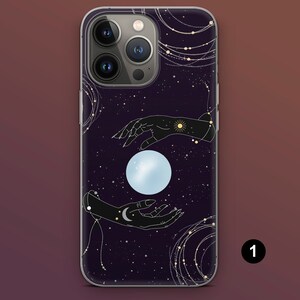 Puede incluir: Funda de tel&eacute;fono con fondo morado oscuro y dise&ntilde;o celestial. El dise&ntilde;o incluye dos manos negras, una luna brillante, estrellas y detalles dorados. Dise&ntilde;ado para un tel&eacute;fono inteligente.