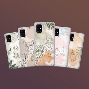 May include: Five phone cases with dog illustrations. Each case features a different dog breed in a line art style, with watercolor-style backgrounds in shades of beige, pink, and green. The cases are arranged in a fan shape against a brown background.