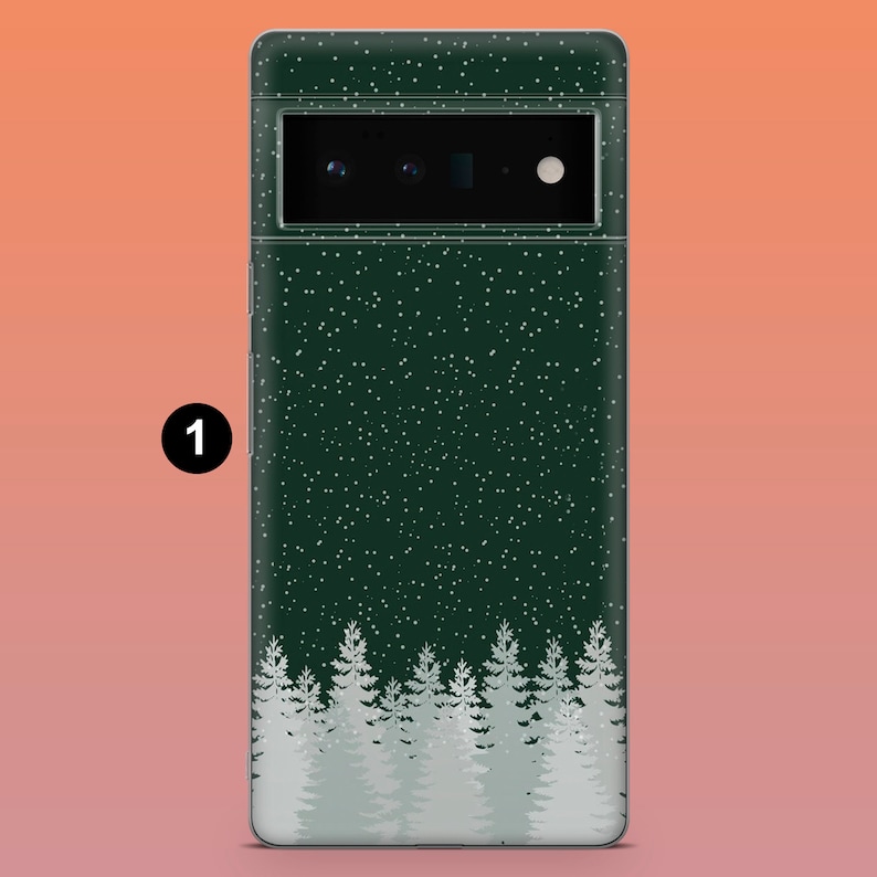 Puede incluir: Funda de tel&eacute;fono verde oscuro con un dise&ntilde;o de bosque invernal. La funda presenta un patr&oacute;n de copos de nieve blancos y una fila de pinos blancos en la parte inferior. La c&aacute;mara y el flash del tel&eacute;fono son visibles en la parte superior.