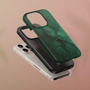 May include: A layered image of a smartphone with a green and black case. The top case has a dark green, marbled design with white speckles. The middle layer is a black case, and the phone itself is silver.