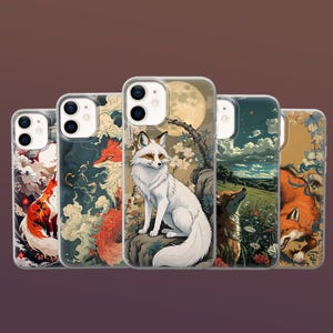 Pode incluir: Cinco capas de telemóvel com ilustrações de raposas. Os designs incluem uma raposa branca sob a lua cheia e raposas num campo. As capas têm uma borda transparente. O estilo é japonês.