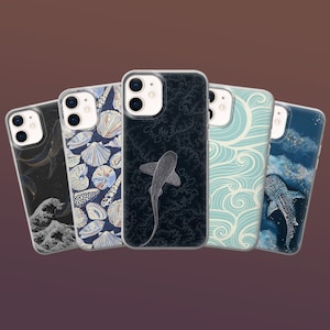 May include: Five clear phone cases with various designs. One case features a whale and wave design, another has seashells, and a third showcases a shark. The other two cases have wave and whale designs. The cases are displayed against a gradient background.