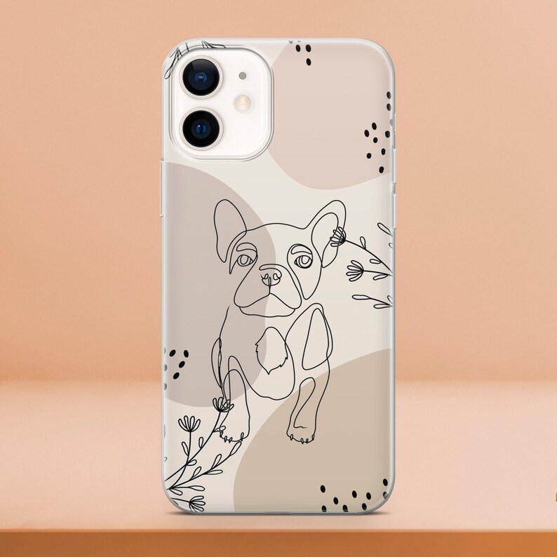 May include: Clear phone case featuring a line drawing of a French Bulldog. The design includes abstract shapes in beige and brown, with black floral accents and dots. The case is designed for an iPhone.