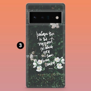 May include: A phone case featuring a dark green floral design with white flowers and the quote, "perhaps this is the moment for which you have been created." The case has a camera cutout and a black border.