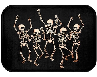 Könnte beinhalten: Eine schwarze Fußmatte mit einem Design aus sechs tanzenden Skeletten. Die Skelette sind weiß mit schwarzen Umrissen und in verschiedenen Posen.