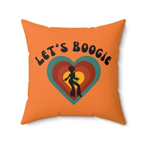 May include: Orange throw pillow with the text "Let's Boogie" in a retro font. A silhouette of a person dancing is inside a heart with concentric circles in shades of red, orange, and yellow.