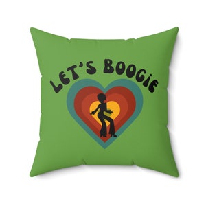 May include: Green throw pillow with the text "Let's Boogie" in black lettering. A silhouette of a person dancing is inside a heart with rainbow stripes.