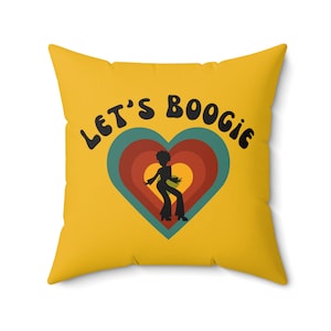 May include: Yellow throw pillow with the text "Let's Boogie" in black, featuring a silhouette of a person dancing in a heart with concentric circles in red, orange, and teal.