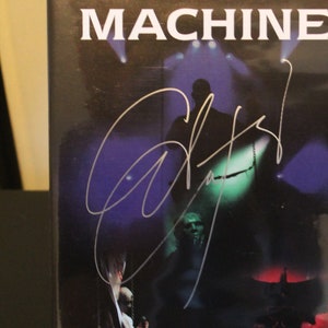 May include: A black DVD case with the title "Saviour Machine Live in Deutschland 2002" and a white signature on the front.