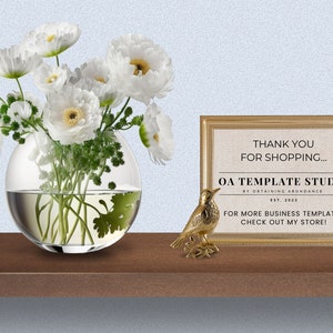 Puede incluir: Un cartel con marco dorado con el texto "Gracias por comprar... OA Template Studio by Obtaining Abundance Est. 2023 Para m&aacute;s plantillas de negocios, &iexcl;visita mi tienda!" Una peque&ntilde;a figurita de p&aacute;jaro de oro se encuentra en un estante de madera frente al cartel. Un jarr&oacute;n de vidrio transparente con flores blancas se encuentra en el estante a la izquierda del cartel.
