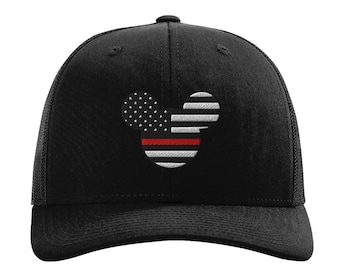 Könnte beinhalten: Eine schwarze Baseballkappe mit einer gestickten Maus-Silhouette auf der Vorderseite. Das Design zeigt ein Muster aus weißen Sternen auf dem linken Ohr sowie horizontale weiße und schwarze Streifen mit einem einzelnen roten Streifen in der Mitte.