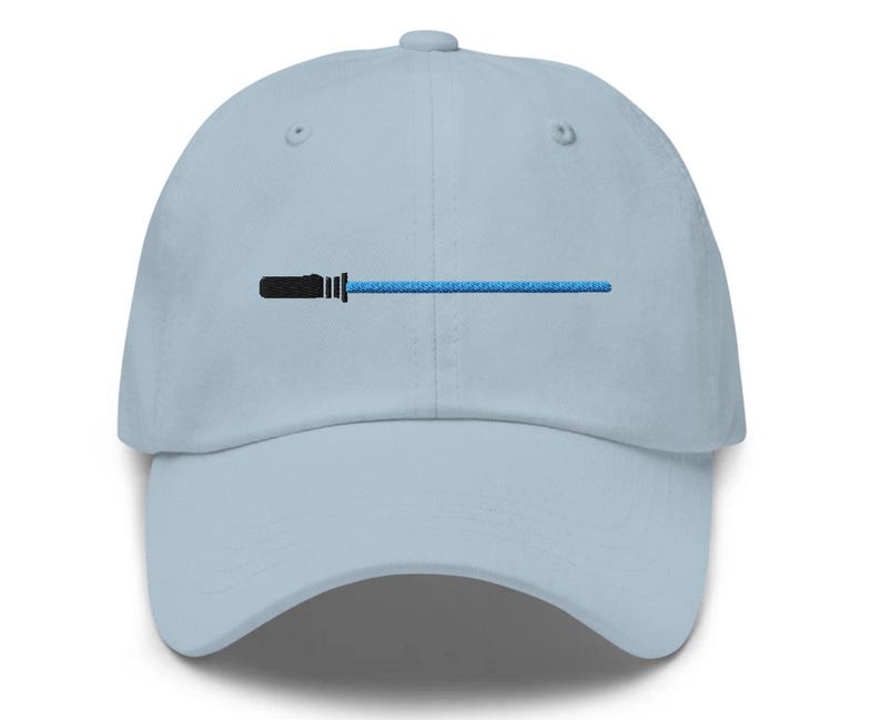May include: A light blue baseball cap with a black and blue lightsaber design embroidered on the front.