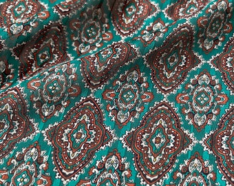 May include: Teal fabric with a repeating pattern of brown and white paisley designs.