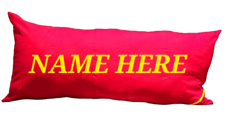 May include: A red rectangular pillow with yellow text that reads "NAME HERE".
