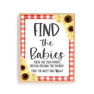 May include: A white sign with red and white gingham border and sunflowers around the edges. The sign says "FIND the Babies THERE ARE TINY BABIES HIDDEN AROUND THE SHOWER. FIND THE MOST AND Win!"