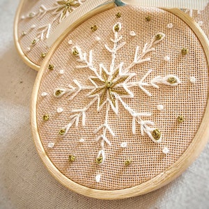 Christmas ornaments in a lovely snowflake design embroidered with white and gold thread on fine greek cotton fabric set on a 3.5 inches bamboo hoop. They come with a white bow and ribbon to hang and gift-wrapped in a beautiful box with ivory ribbon