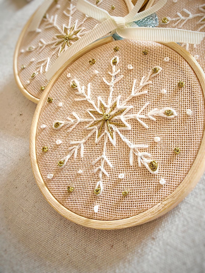 Christmas ornaments in a lovely snowflake design embroidered with white and gold thread on fine greek cotton fabric set on a 3.5 inches bamboo hoop. They come with a white bow and ribbon to hang and gift-wrapped in a beautiful box with ivory ribbon