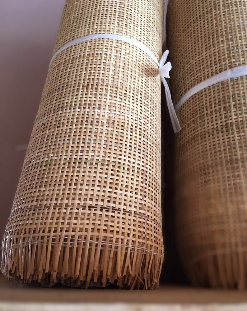 Rolls of natural square woven cane webbing. The webbing is a light brown color and has a woven pattern.