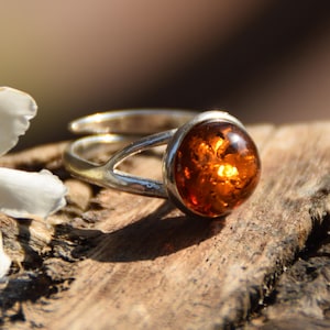 Glanzende, verstelbare ring gemaakt met een ronde, natuurlijke cognacbruine ambersteen en 925 sterling zilver, MJ Baltica, BP123