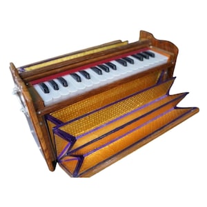 May include: A wooden harmonium with a keyboard of black and white keys. The bellows are gold with purple trim. The instrument has a red accent above the keys and gold trim.